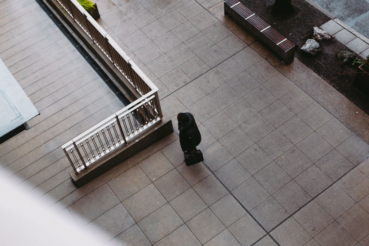 Person surrounded by modern pressures representing the internal rat race