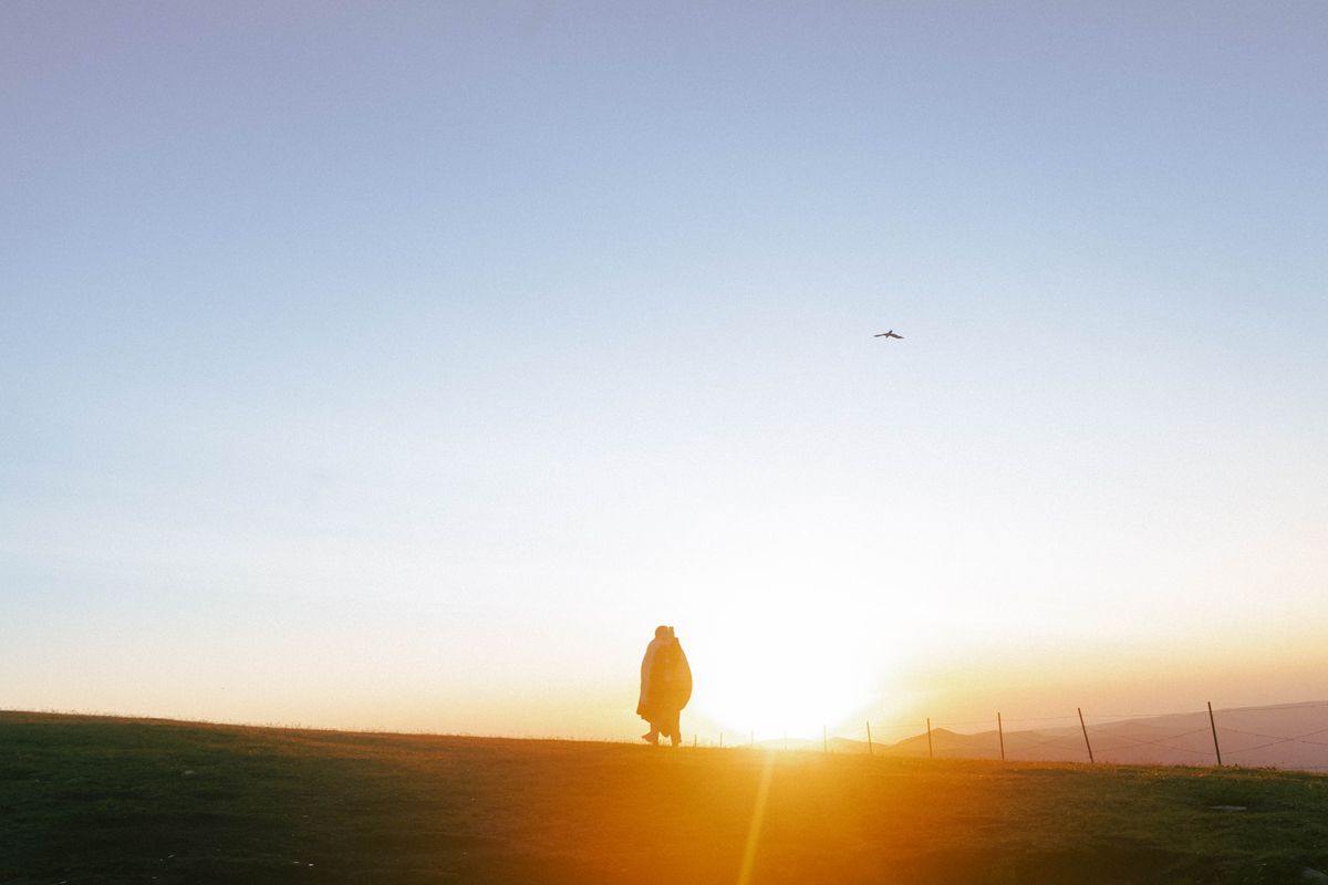 Person walking toward an open landscape as a symbol of consciously choosing a meaningful life